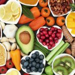 Health food for fitness concept with fresh fruit, vegetables, pulses, herbs, spices, nuts, grains and pulses. High in anthocyanins, antioxidants,smart carbohydrates, omega 3 fatty acids, minerals and vitamins.