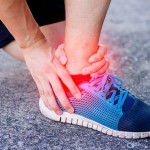 Runner touching painful twisted or broken ankle. Runner training accident