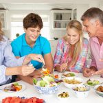 Parents with teenage children enjoying meal at home
