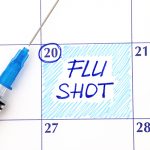 Reminder Flu Shot in calendar with syringe. Close up.